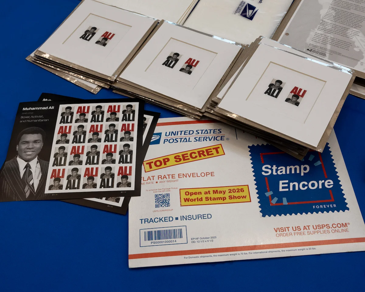 The Stamp Encore envelope on a table with Muhammad Ali stamps